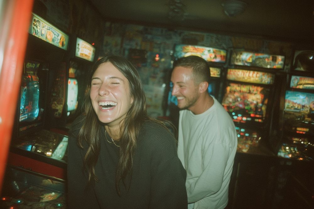 A couple laughing together in an arcade.