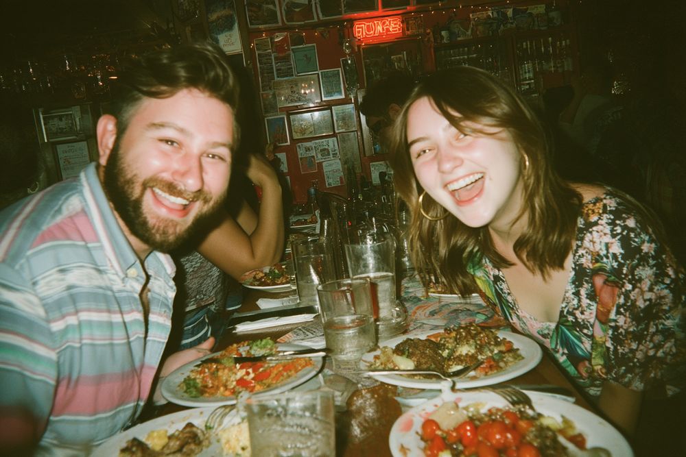 A couple laughing over dinner at a restaurant.